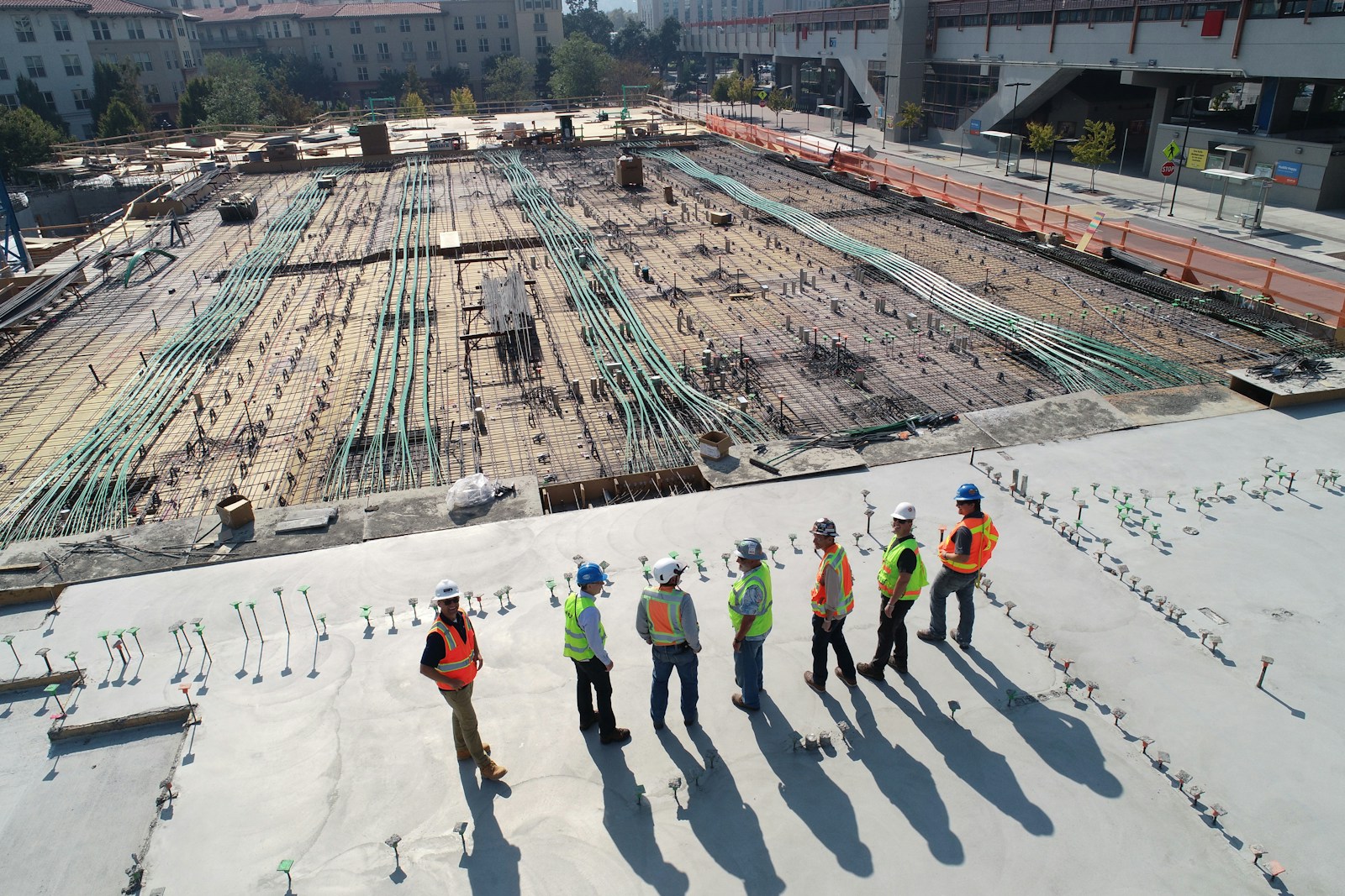 seven construction workers standing on white field Mitigating Risks With Construction Insurance