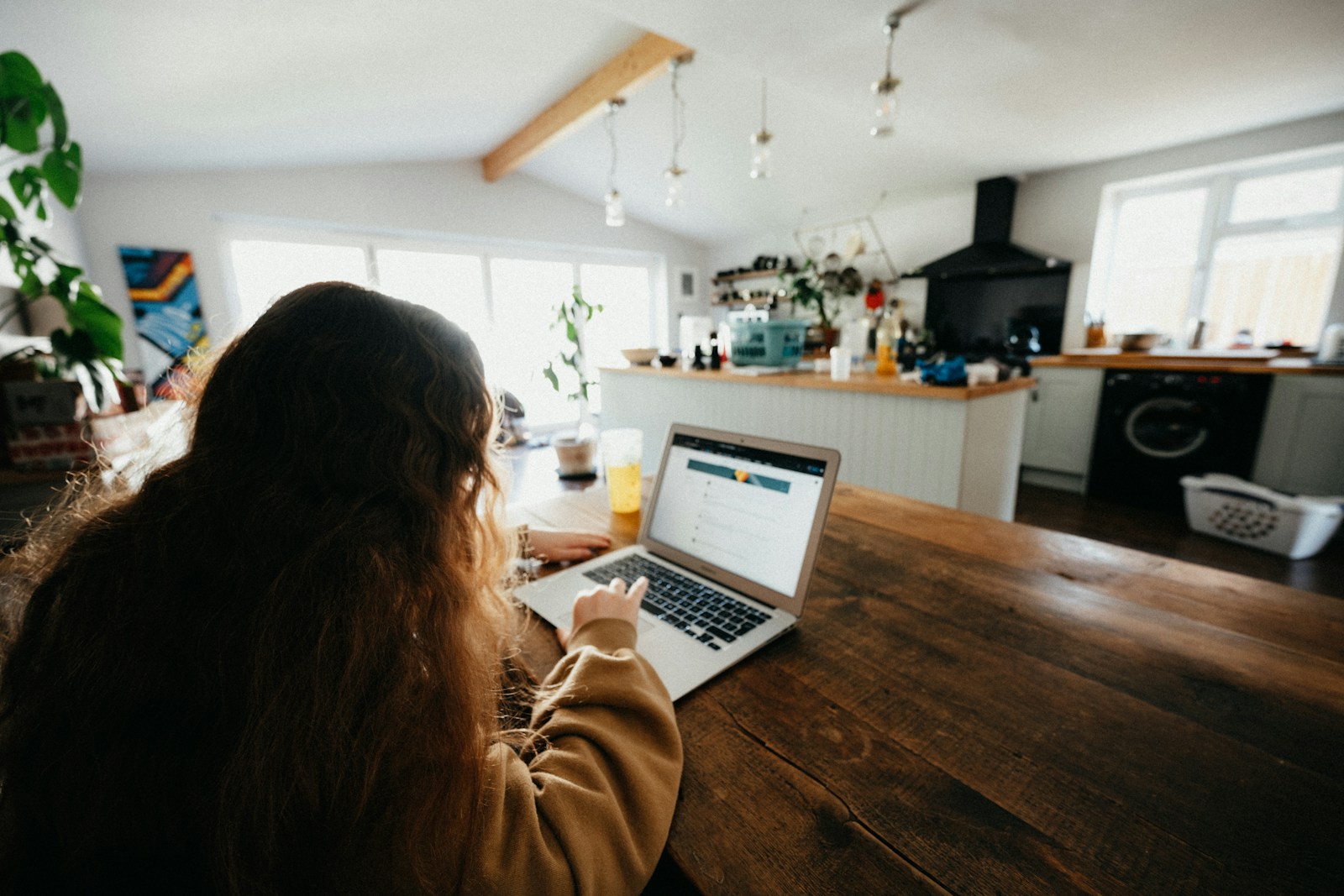 woman in brown sweater using macbook pro, renters